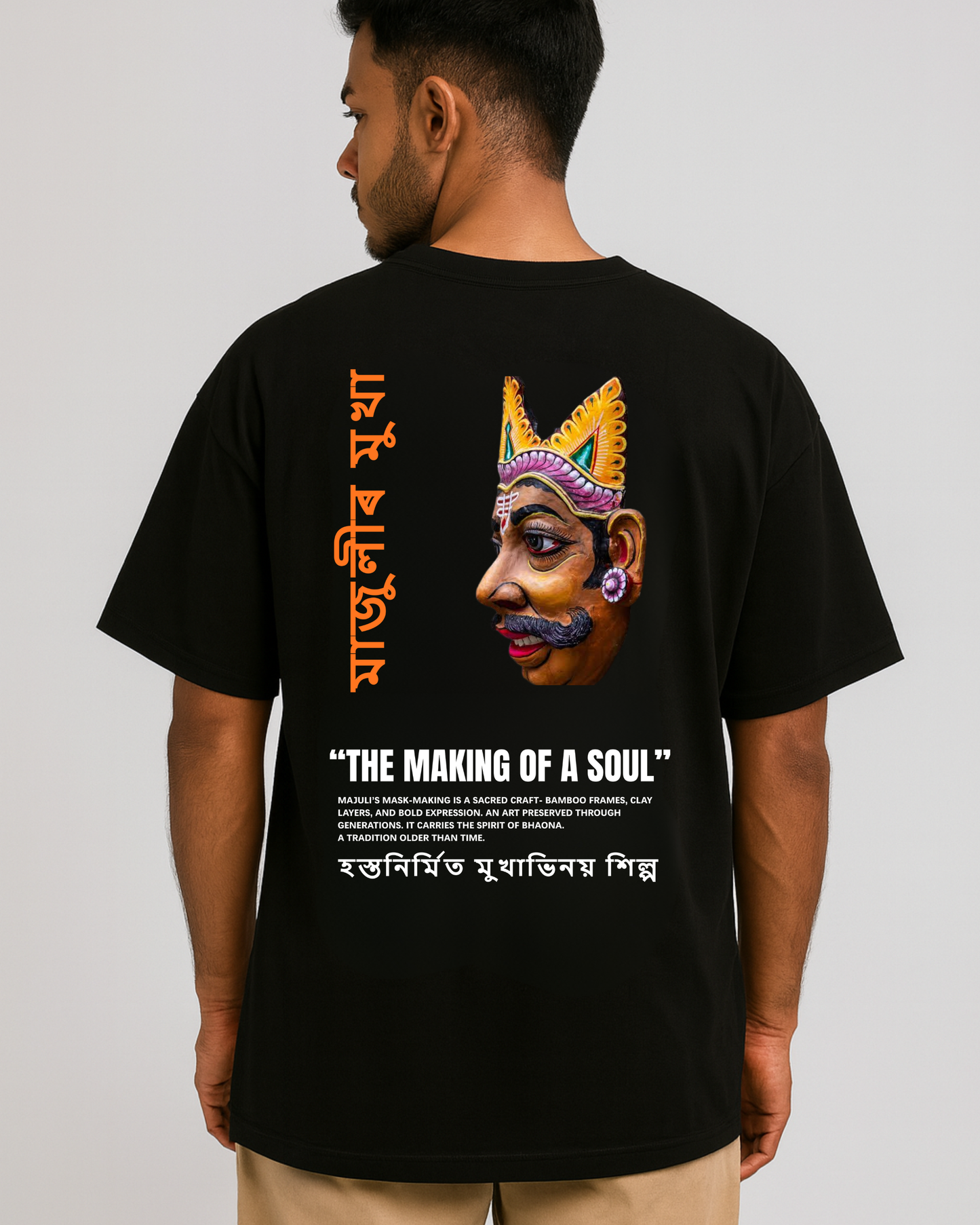 Majuli mask art T-shirt — Assamese Mukha Shilpa design on back, cultural heritage artwork, oversized black tee (male model).