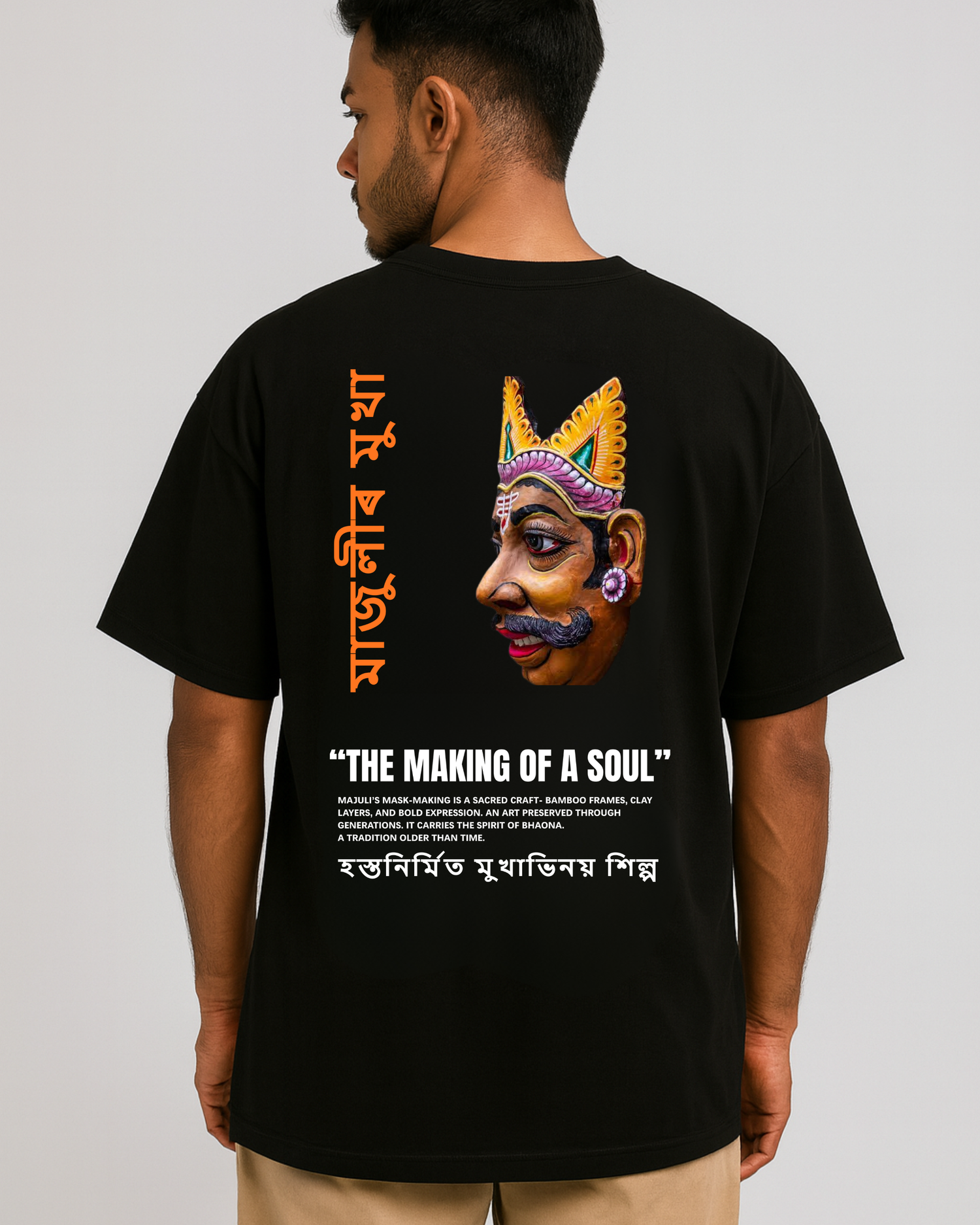Majuli mask art T-shirt — Assamese Mukha Shilpa design on back, cultural heritage artwork, oversized black tee (male model).