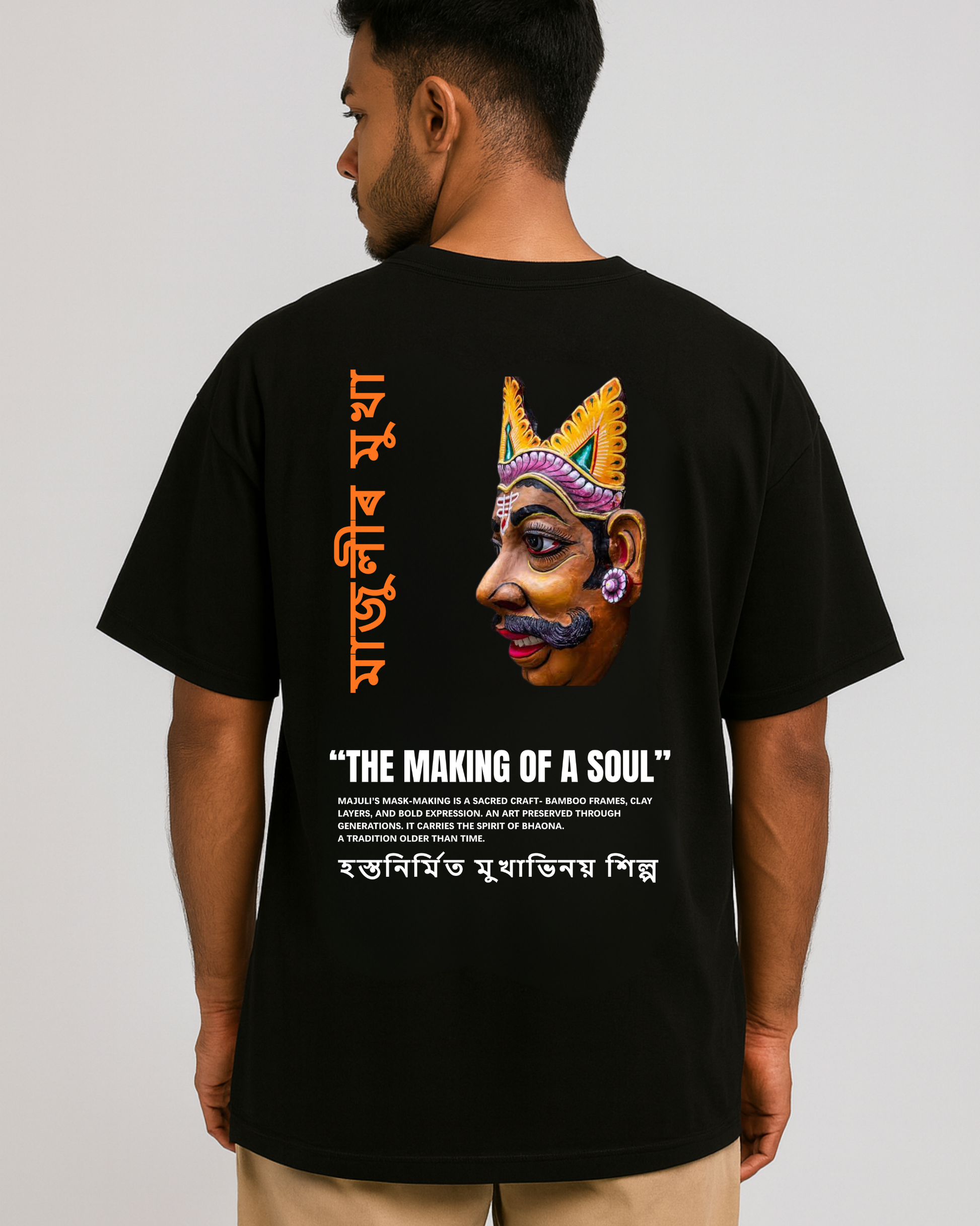 Majuli mask art T-shirt — Assamese Mukha Shilpa design on back, cultural heritage artwork, oversized black tee (male model).